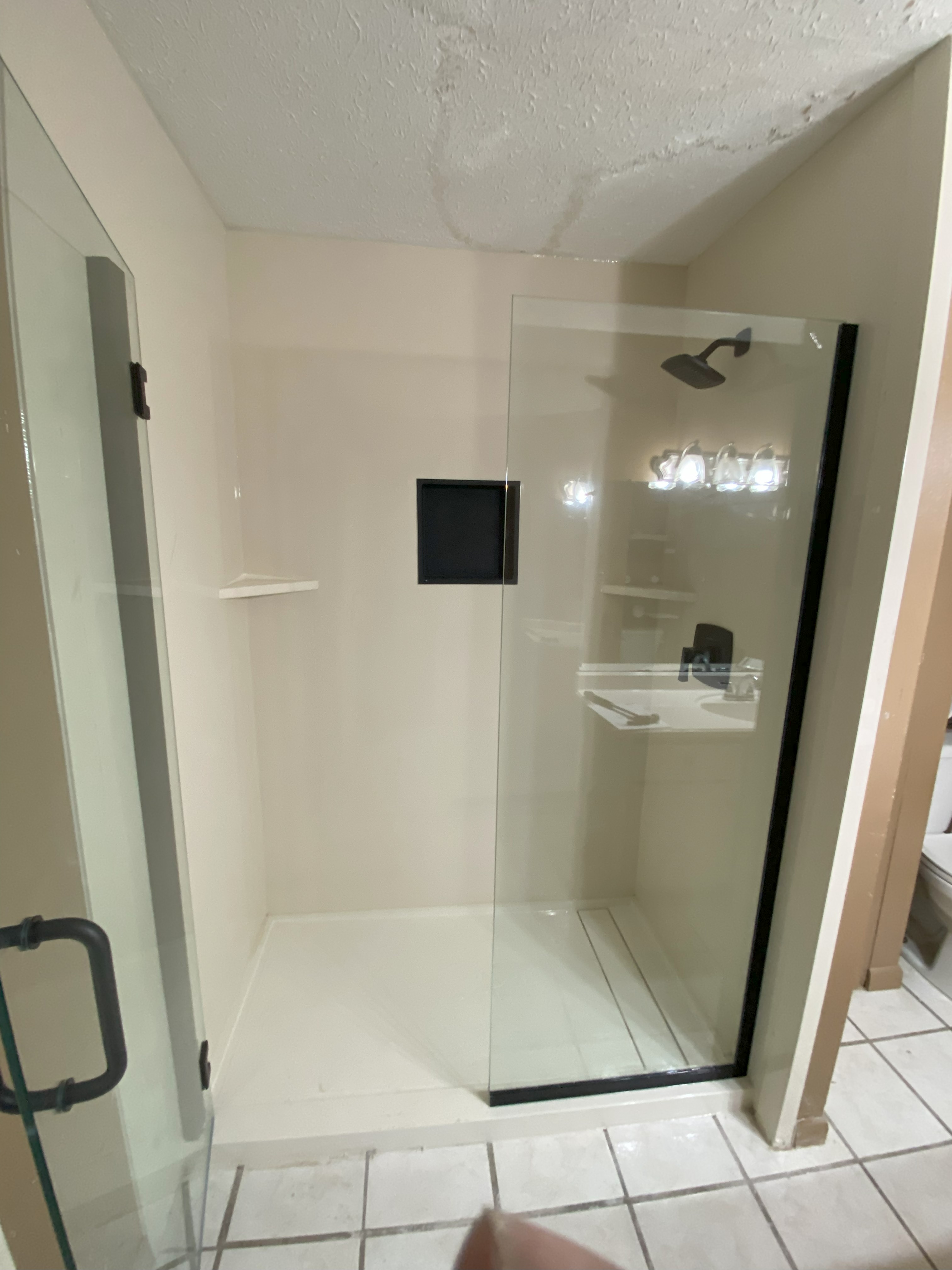 Walk-in shower with swing door and built-in storage